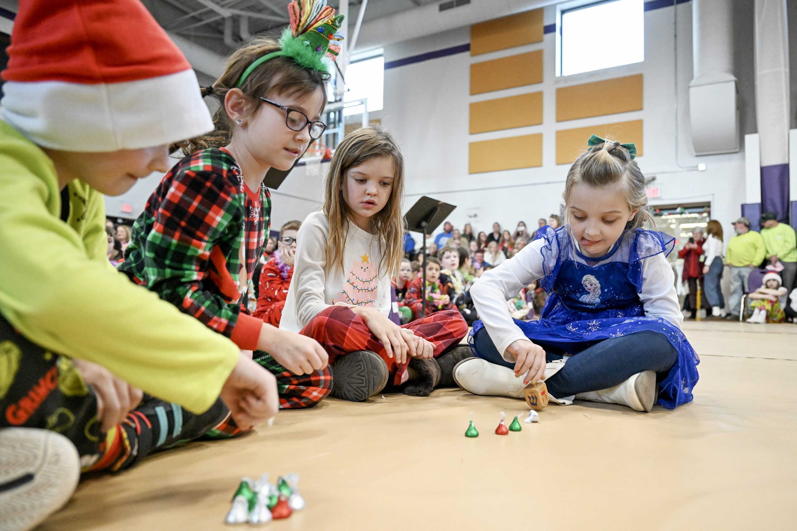 young students play with a dreidel