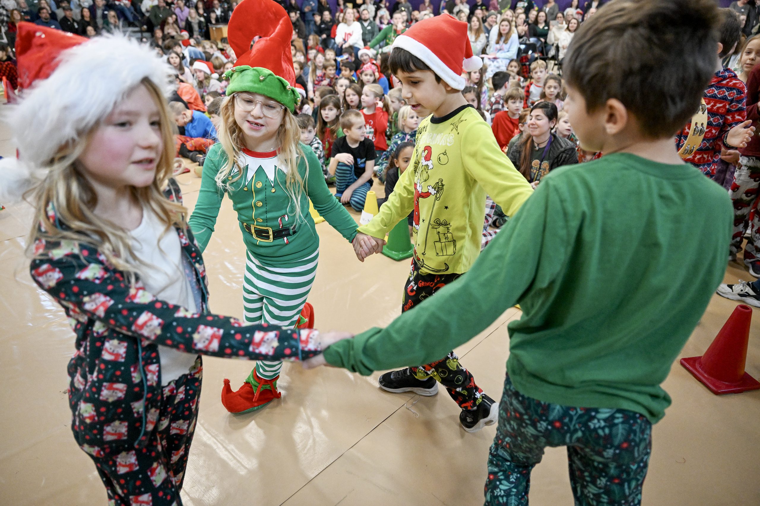 young students hold hands and dance in a circle