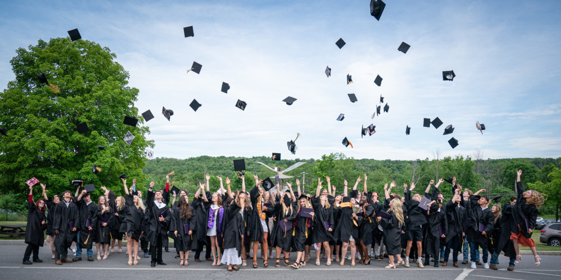 graduates toss their caps into the air