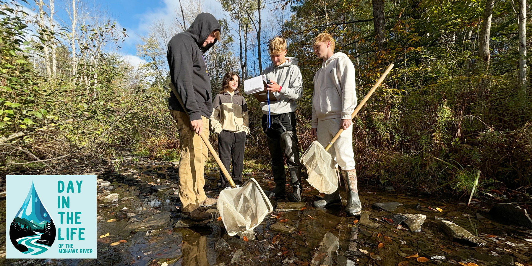 students stand in a creek to conduct an experiment