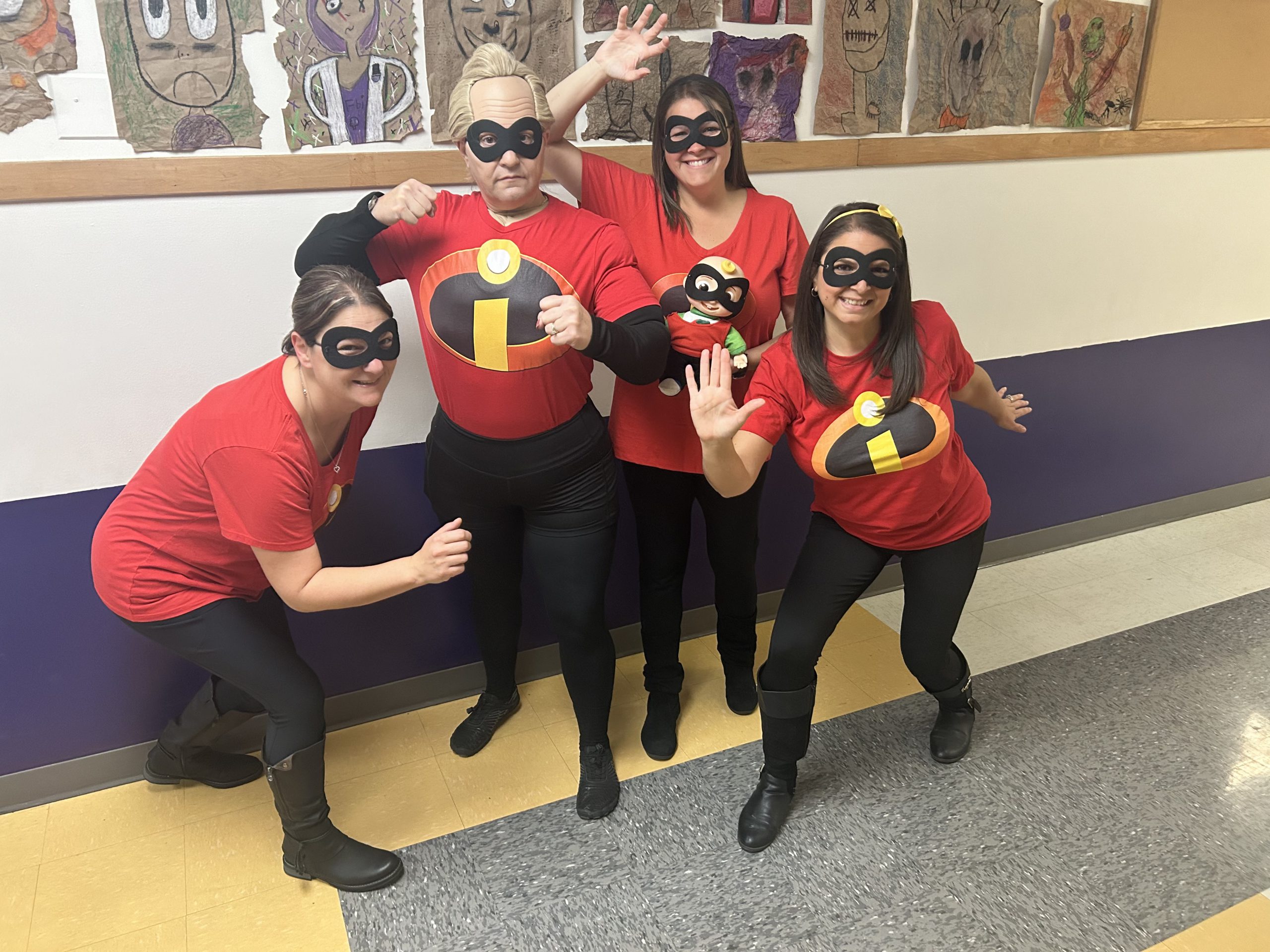 a group of teachers pose as superheroes for Halloween