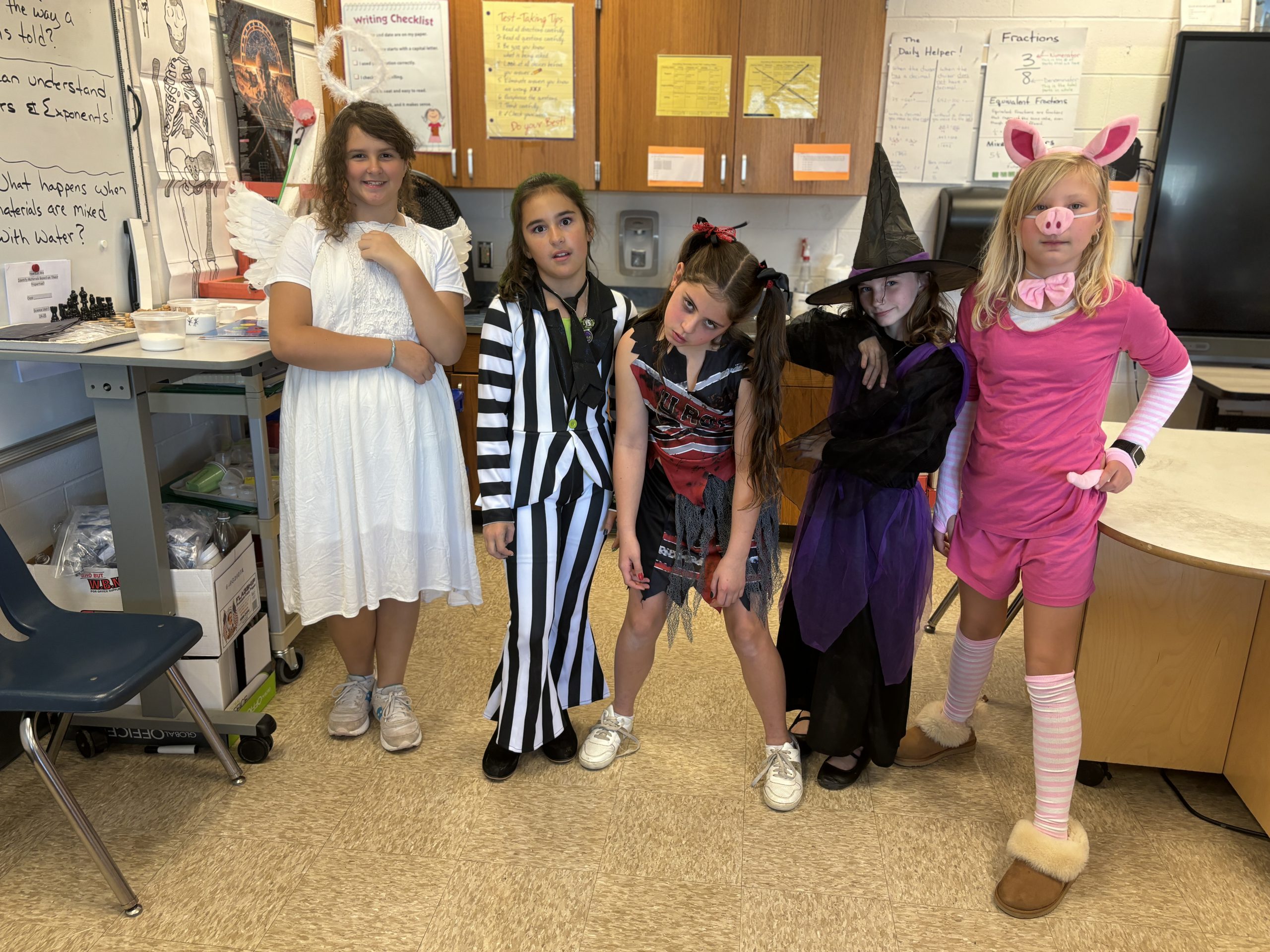 a group of young female students pose in the classroom for Halloween