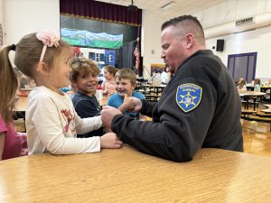 a man plays thumb war with small children