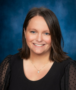 a woman with dark hair wearing a black shirt smiles